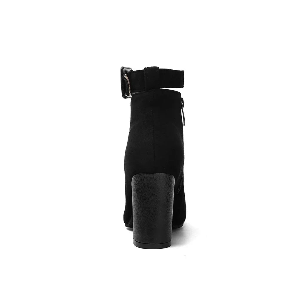 Pair of women's elegant buckle ankle boots, pointed toe & block heel for fashionable comfort.