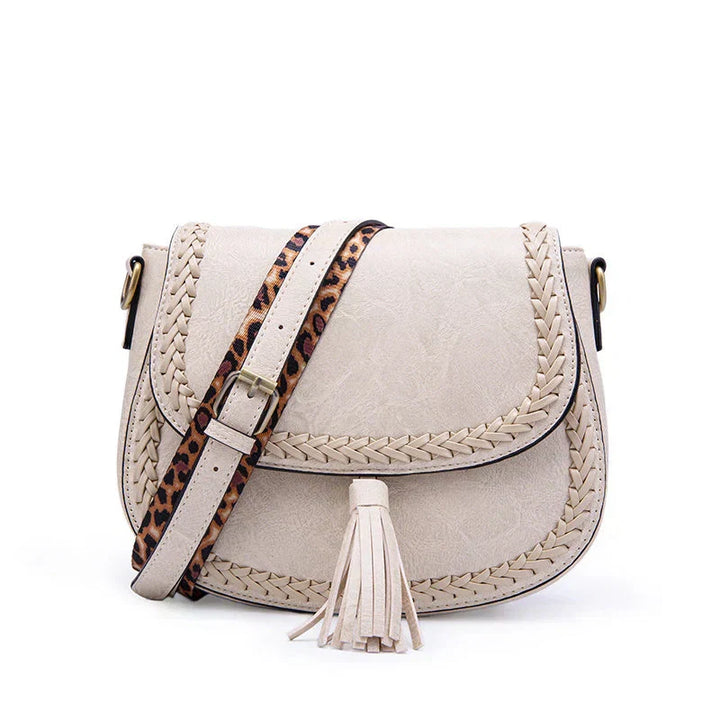 Fashionable women's crossbody handbag with elegant tassel detail, adjustable shoulder strap & magnetic closure.