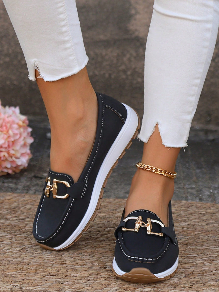 Close-up of chic women's buckle loafers, highlighting stylish buckle detail & comfortable flat design.