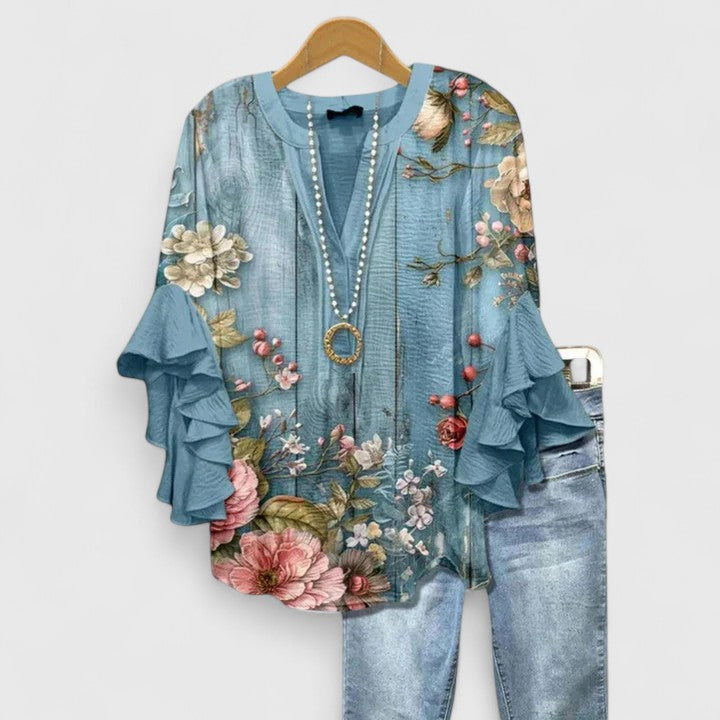 Floral print women's blouse with ruffled long sleeves. A chic and elegant top for women's apparel collections.