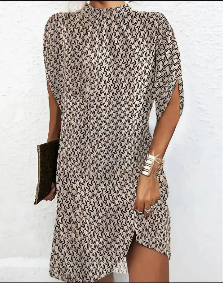 Stylish cocktail party mini dress for women, with a modern mock neck and dramatic cape sleeves.