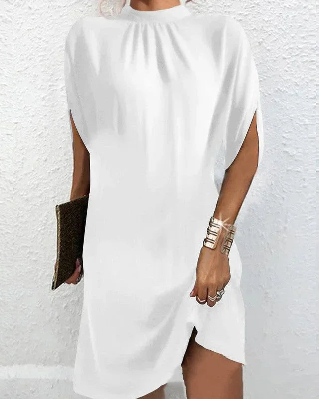 Women's chic mini dress with a sophisticated mock neck, flowing cape sleeves, & a flattering short length.