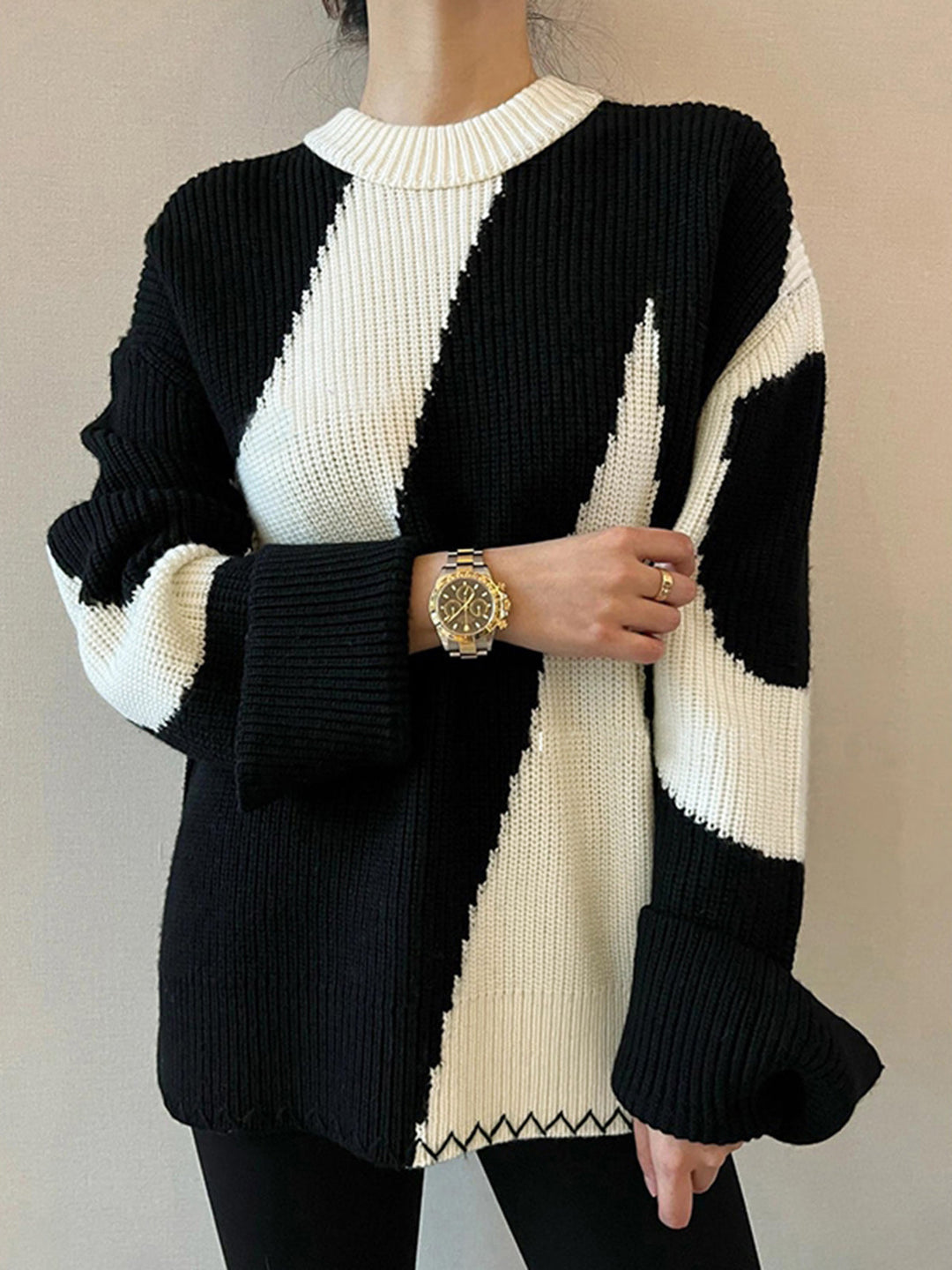 Close-up of a stylish women's oversized zebra print sweater, showcasing its soft texture & bold pattern.