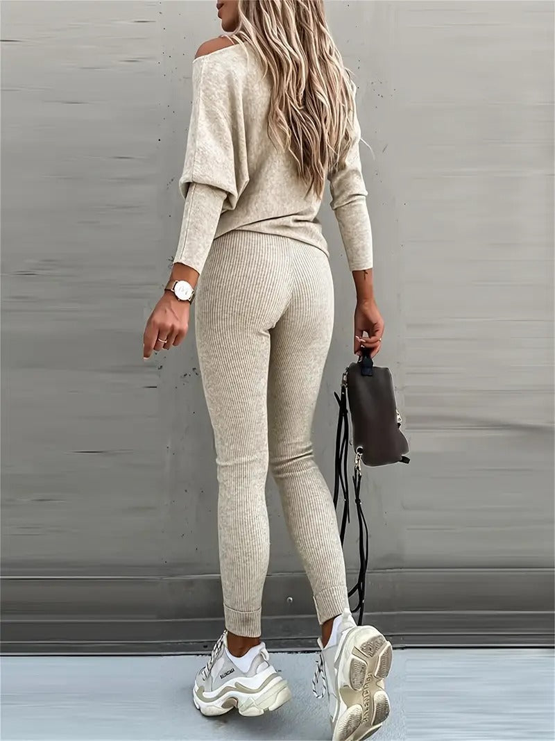 Model wears a stylish women's ribbed long-sleeve top, part of a versatile two-piece lounge set. Casual chic fashion.