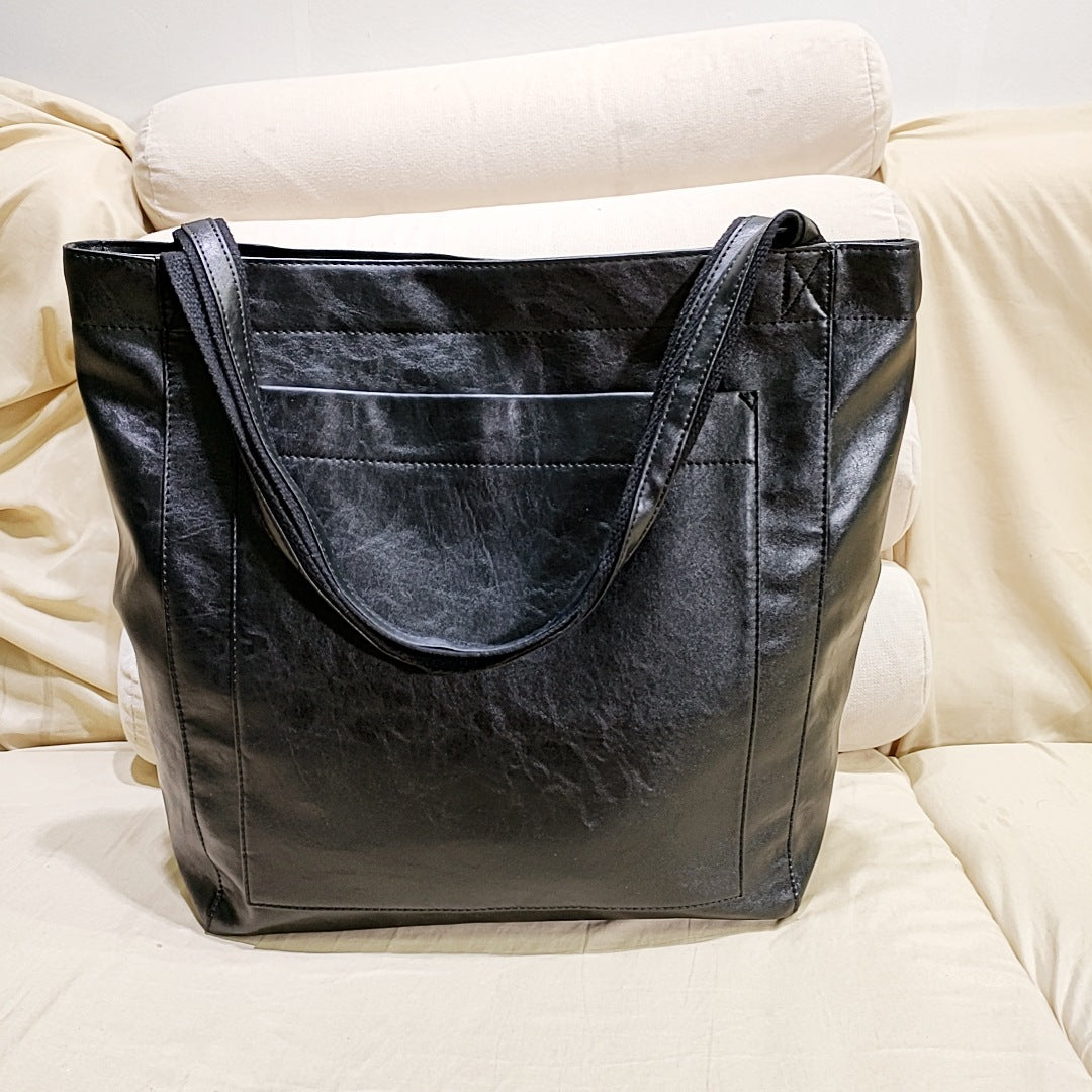Stylish black structured tote handbag for women, a chic fashion accessory that works as a shoulder bag or crossbody.