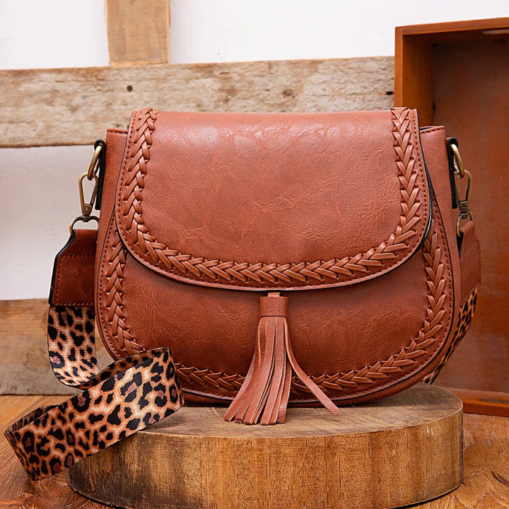 Chic women's tassel saddle bag in a versatile neutral color, perfect as a crossbody or shoulder bag.