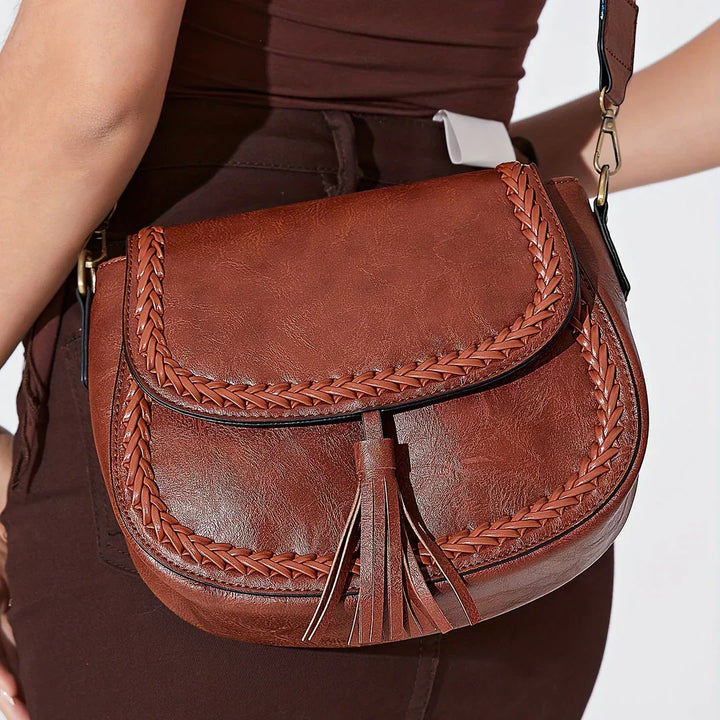 Fashionable women's crossbody saddle bag adorned with playful tassels, ideal for any outfit.