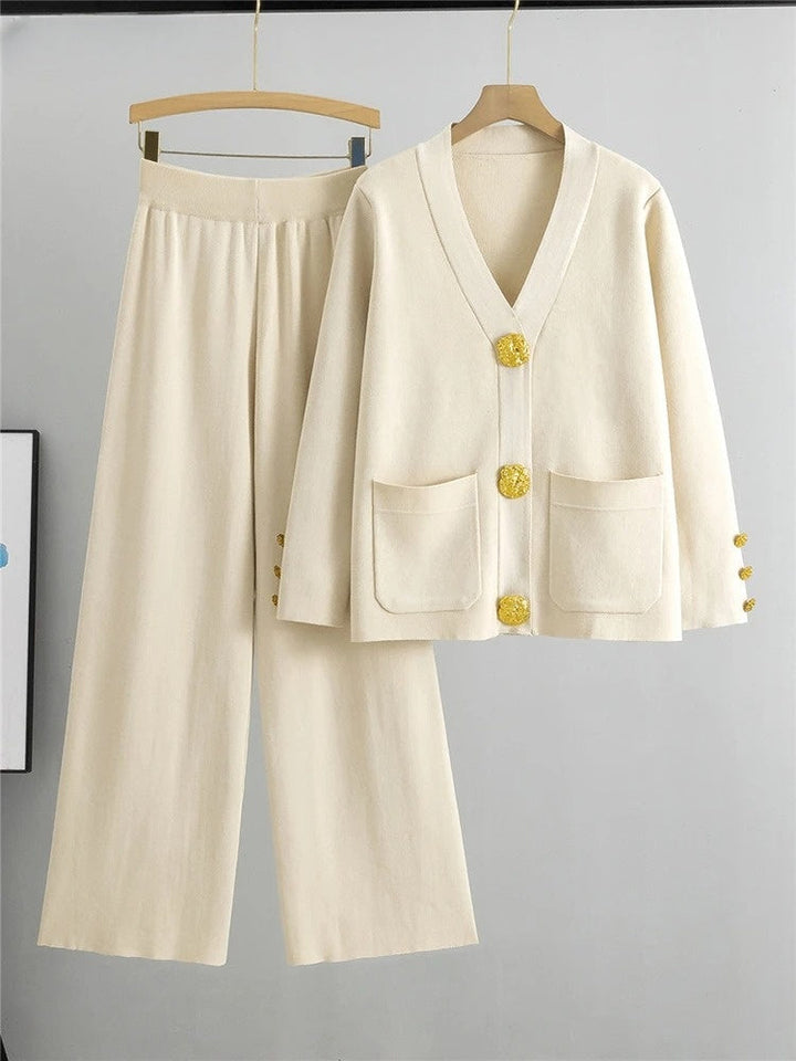 Chic women's two-piece outfit with elegant gold trim. Includes a stylish top and wide-leg trousers for a versatile look.