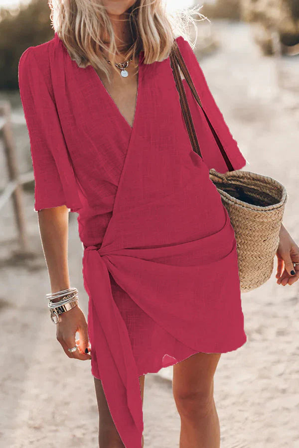 Close-up of the elegant draped fabric detail on a women's V-neck mini dress, showcasing its soft, flowing material.
