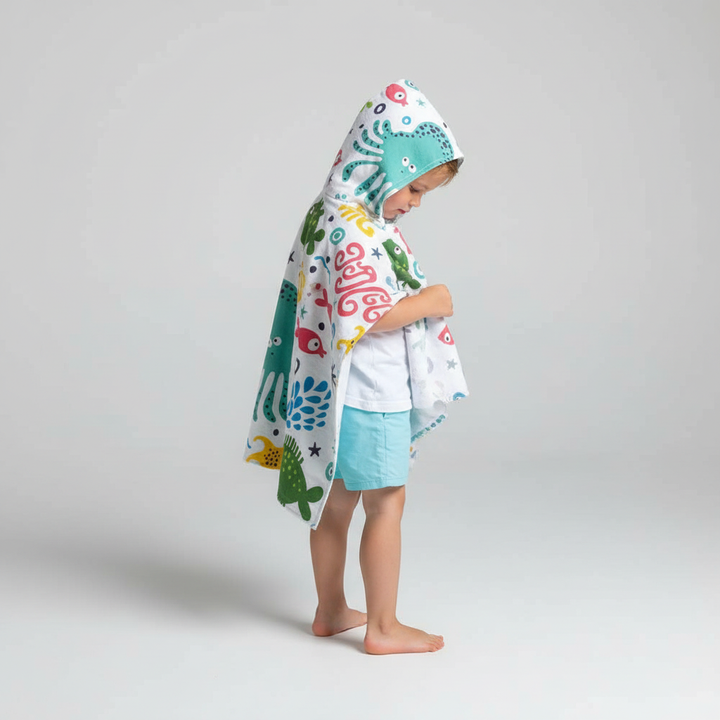 Back view of child in SeaCover microfiber hooded poncho towel, beach scene background, sun protection