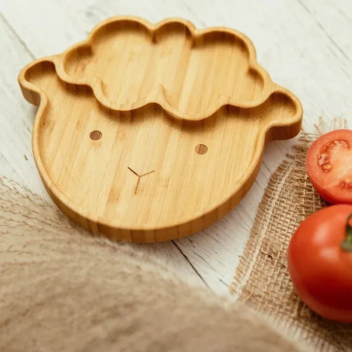 Toddler's eco-friendly bamboo tableware, suction cup prevents spills, durable & safe.