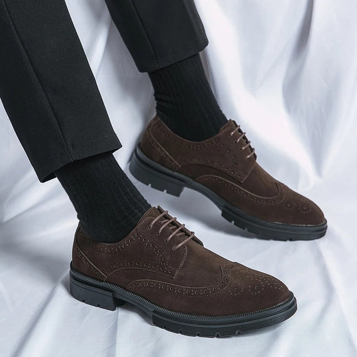Detailed view of men's brown suede brogues, showcasing the classic perforations and high-quality finish.