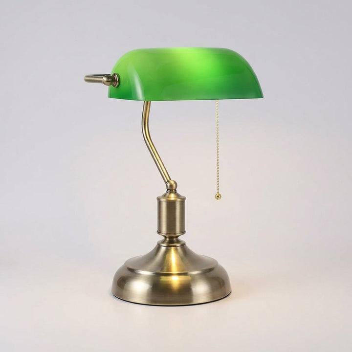 Close-up of a LuxeGlint classic banker lamp, showing intricate metal base & rich green glass shade