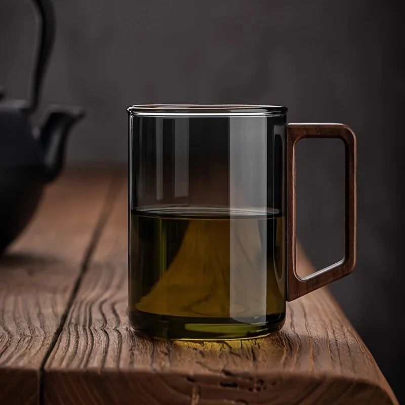 Stylish smoke gray borosilicate glass coffee mug with comfortable wooden handle for modern kitchenware.