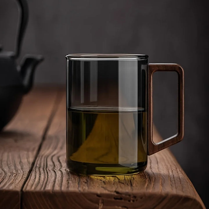 Stylish smoke gray borosilicate glass coffee mug with comfortable wooden handle for modern kitchenware.