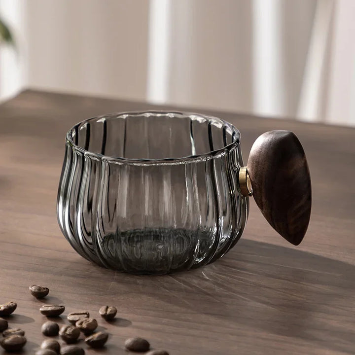 Clear borosilicate glass drinkware with ergonomic wood handle, showcasing your hot or cold beverage.
