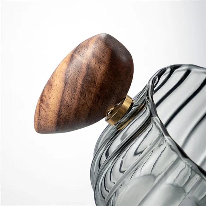 Sleek unisex glass mug with natural wood handle, enhancing your coffee or tea drinking experience.