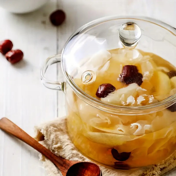 Elegant transparent glass cooking pot, essential kitchenware for preparing and serving hot soups and stews.