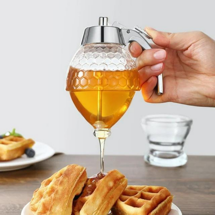 Clear plastic drip-free honey dispenser with elegant stand, perfect kitchen tool for breakfast & baking.