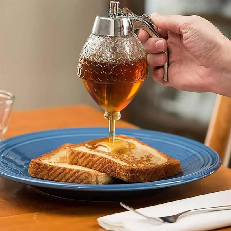 Elegant clear plastic drip-free syrup server with stand, ideal for breakfast, baking, and kitchen condiments.