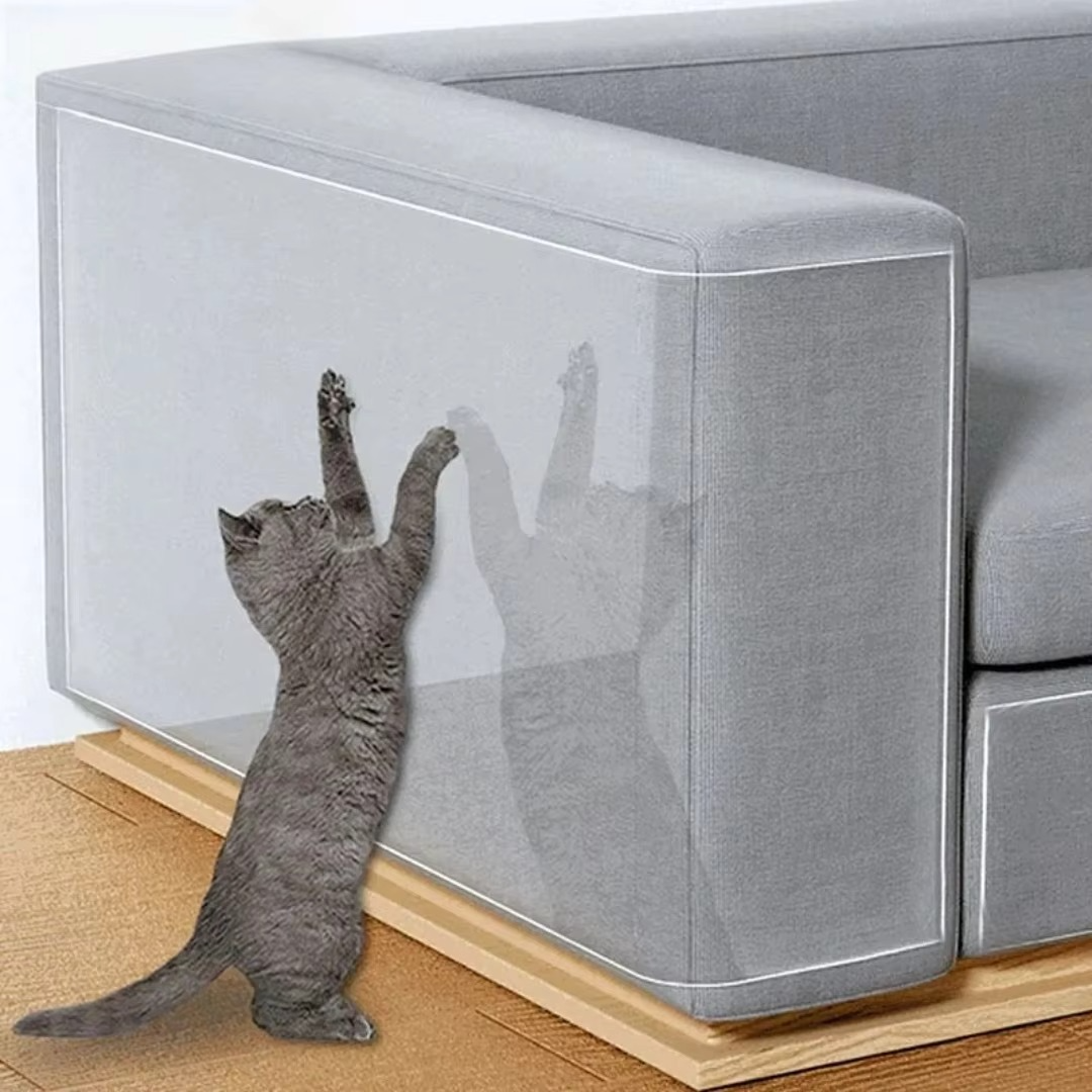 Clear self-adhesive cat scratch shield protecting a sofa's upholstery from pet damage.