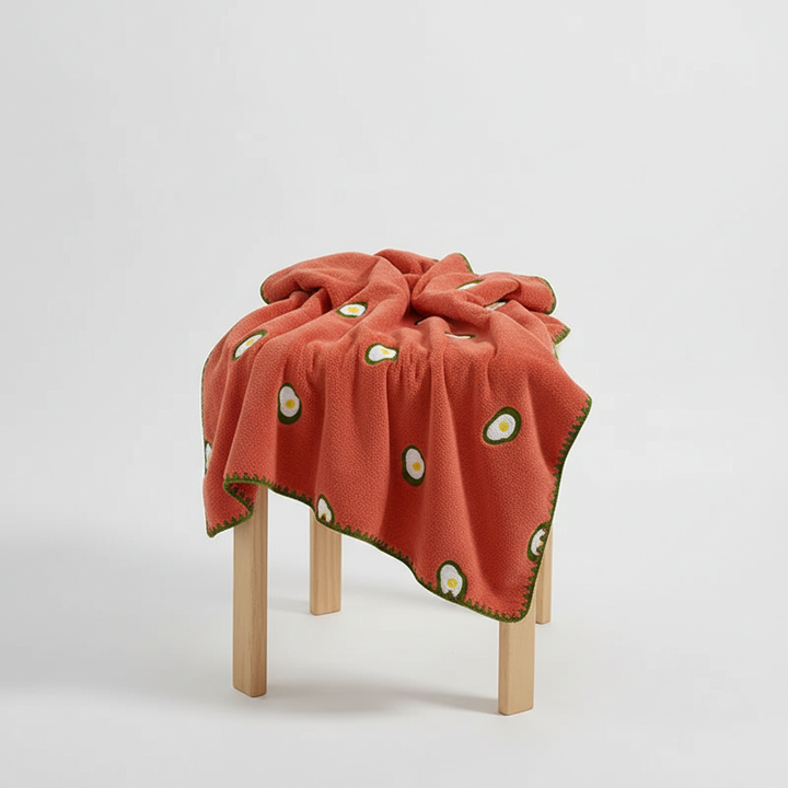 Decorative fruit pattern TropiTowel cotton hand towel draped over a rack, adding cheer to a bathroom