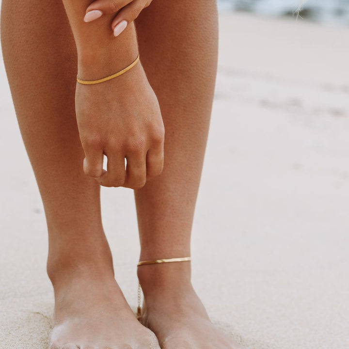 Stylish adjustable herringbone chain bracelet in radiant gold, women's fashion jewelry.