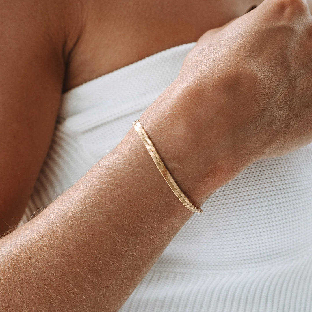 Women's two-tone gold & silver herringbone chain bracelet, elegant and modern accessory.
