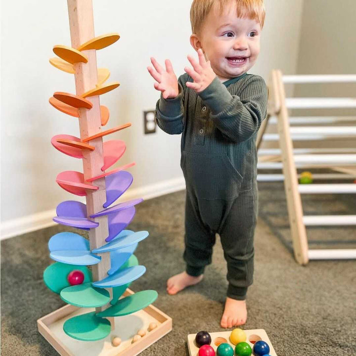 Colorful wooden rainbow sound tree toy with marbles cascading, engaging children in sensory play & early development.