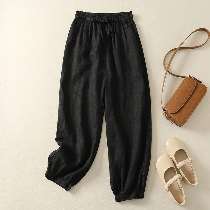 Black women's comfortable harem pants with a relaxed fit & tapered leg, great for versatile spring & summer style.
