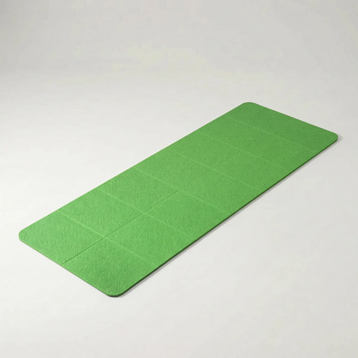Green compact foldable travel yoga mat, designed for easy portability & non-slip grip during yoga, pilates & exercise.
