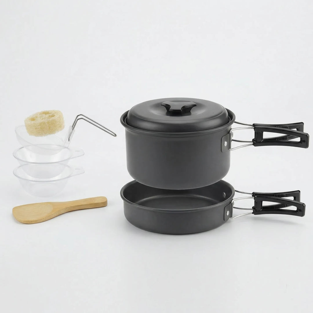 Compact camping cookware set boiling water on a camp stove in a wilderness outdoor setting.
