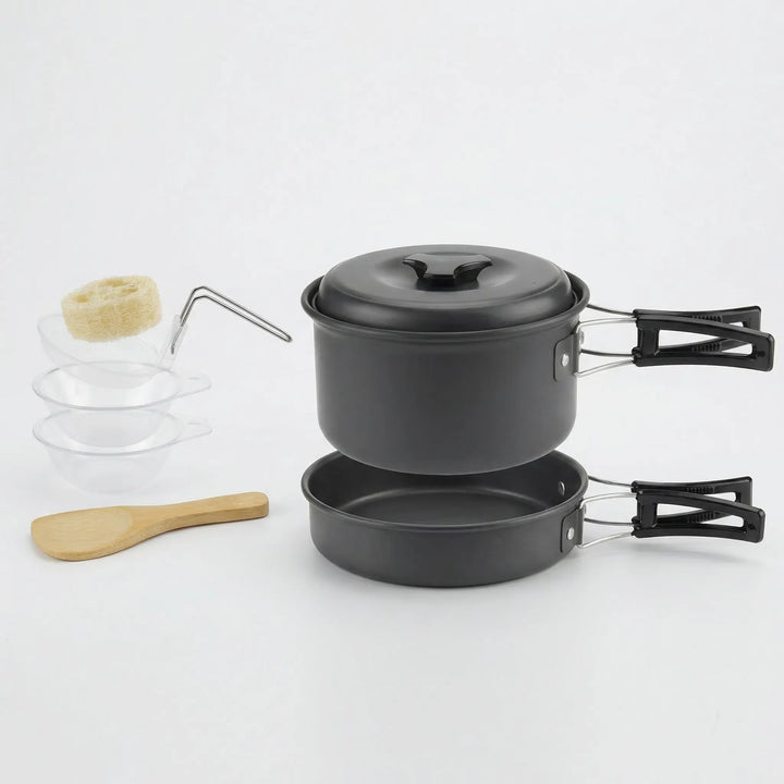 Compact camping cookware set boiling water on a camp stove in a wilderness outdoor setting.