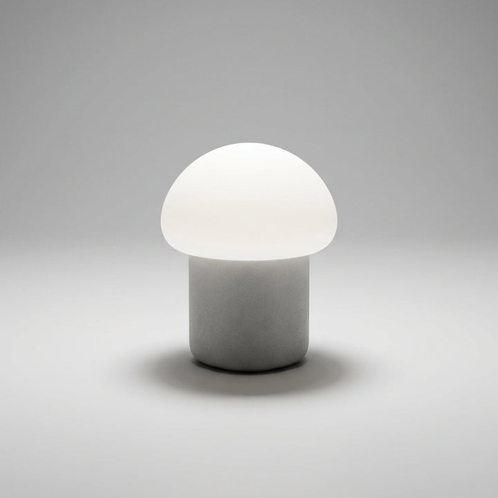 Close-up of Mushino mushroom LED lamp, frosted white, diffusing soft, warm light.