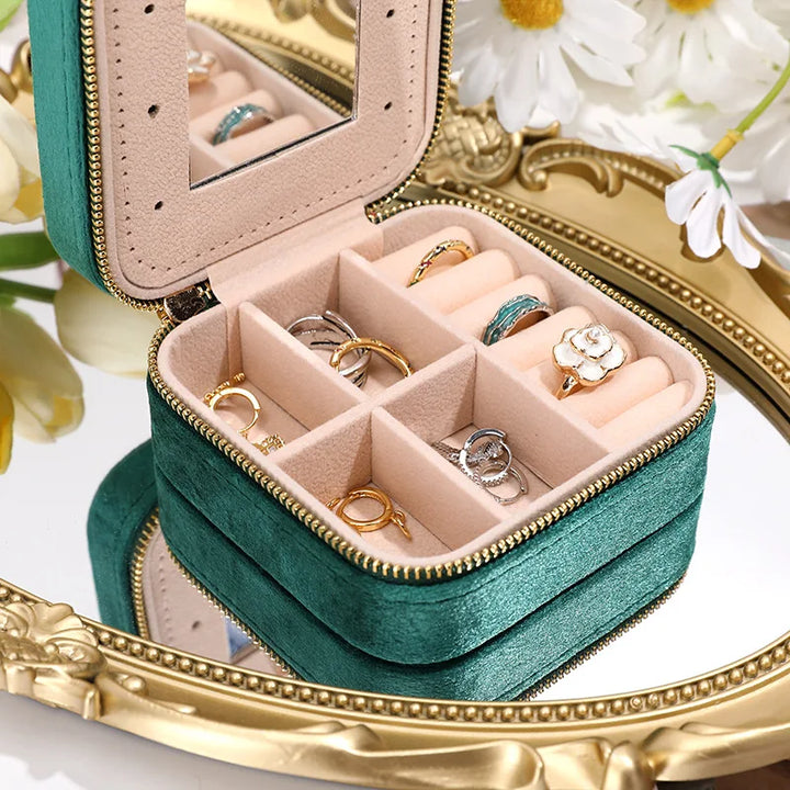 Stylish green travel jewelry organizer with mirror, a compact velvet case for rings, necklaces, & studs.