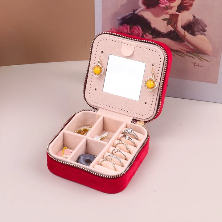 Assorted women's travel jewelry boxes with mirror, velvet organizers in pink, blue, green, gray for accessories.