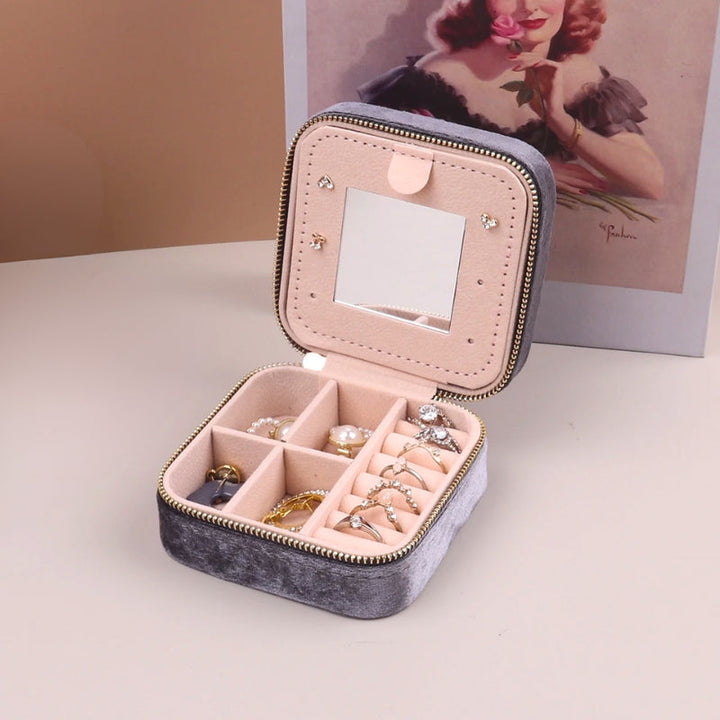 Compact women's travel jewelry organizer, a sleek velvet case with built-in mirror for rings & earrings.