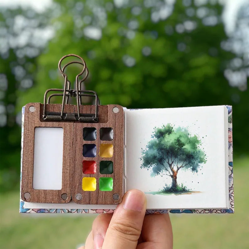 Miniature watercolour set in a sturdy case, offering complete painting supplies for travel art projects.