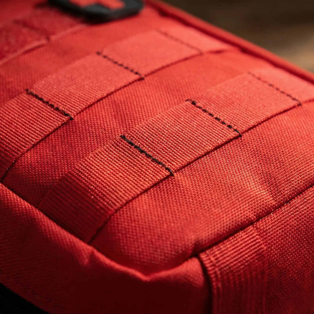 Black tactical first aid pouch, MOLLE compatible. A durable, compact emergency kit for outdoor survival & travel.