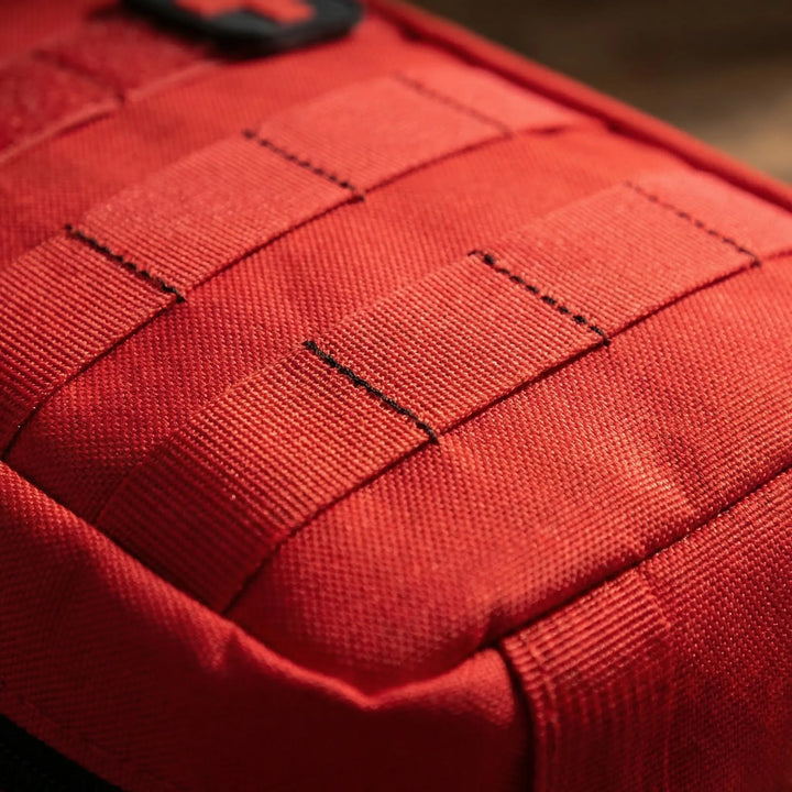 Black tactical first aid pouch, MOLLE compatible. A durable, compact emergency kit for outdoor survival & travel.