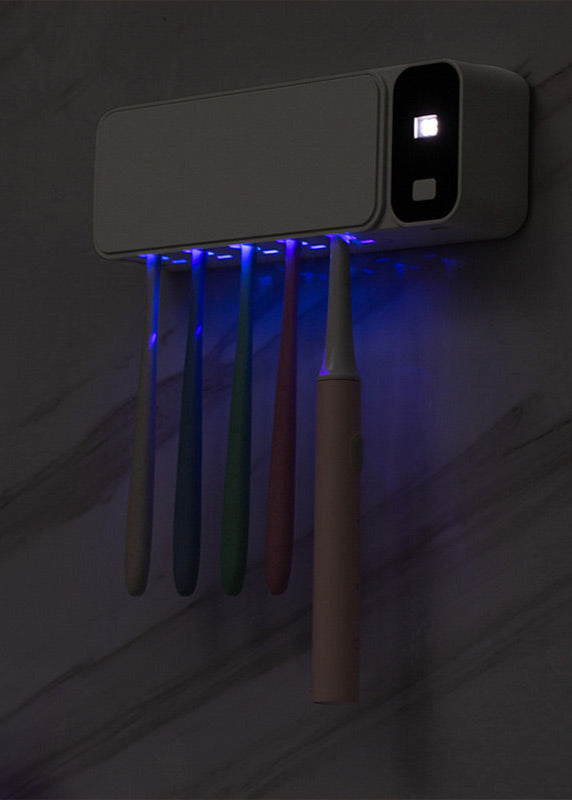 White UV SteriliBox toothbrush holder mounted on a bathroom wall, organizing dental essentials