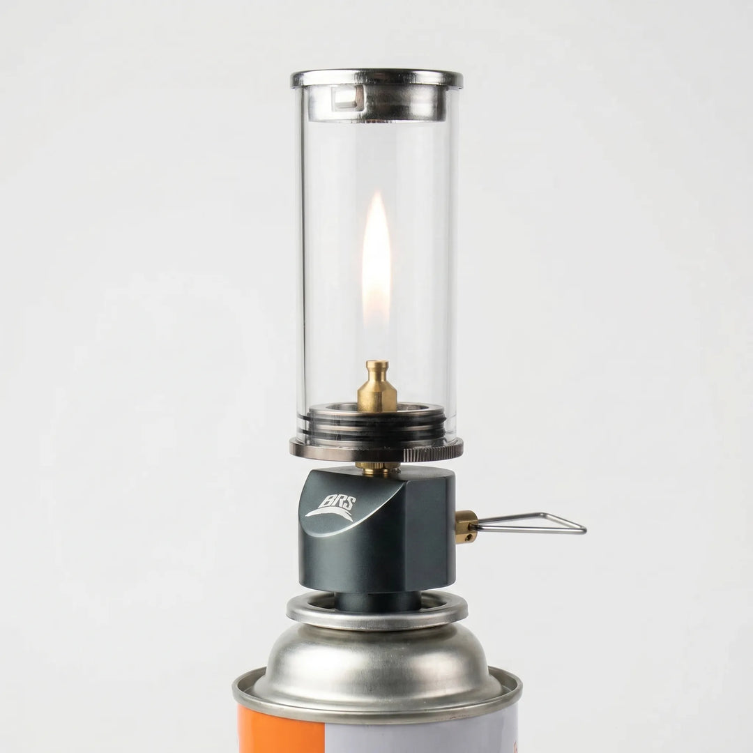 Compact windproof gas camping lamp providing warm candle-like glow for outdoor ambiance & tent lighting.