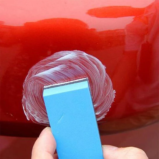 Applying Fast Car Scratch Repair solution to a car's painted surface to quickly remove scratches and restore shine.