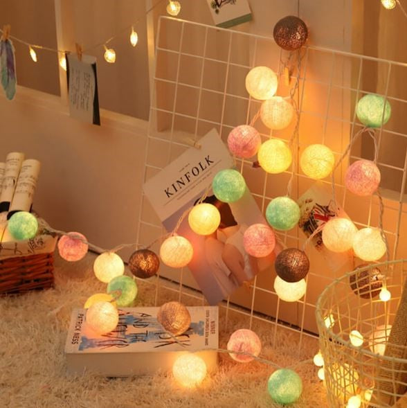 String of decorative cotton ball lights with a vibrant mix of colors for lively room decor.