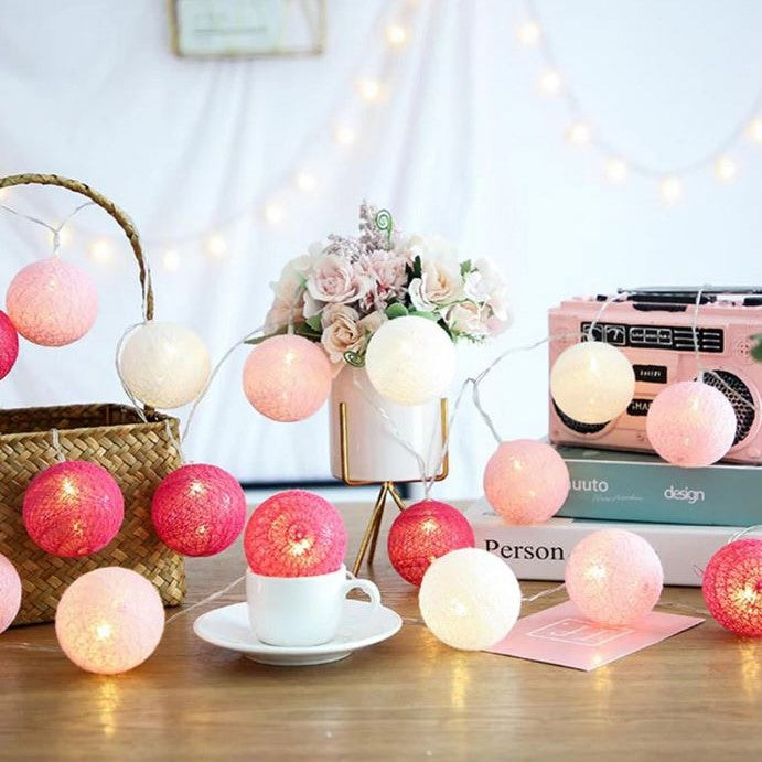 Cotton ball LED string lights accenting a shelf, enhancing home decor with gentle ambient light.