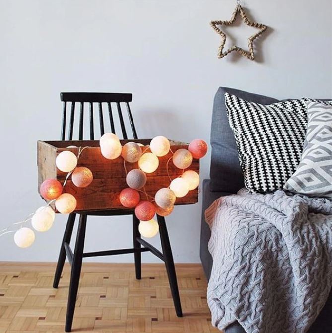 Cotton ball string lights illuminating a dark corner, bringing cozy, ambient LED light to home decor.
