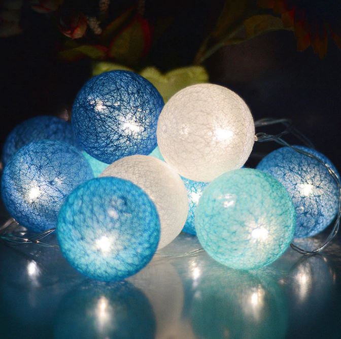 Close-up of a soft cotton ball light, illuminating with a warm LED glow, home decor.