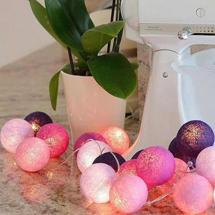 Fairy lights decorating a party table, colorful cotton balls adding festive mood lighting.