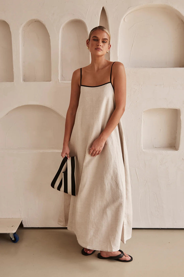 Cream oversized maxi dress with contrast trim, square neck, spaghetti straps. Flowy summer fashion.