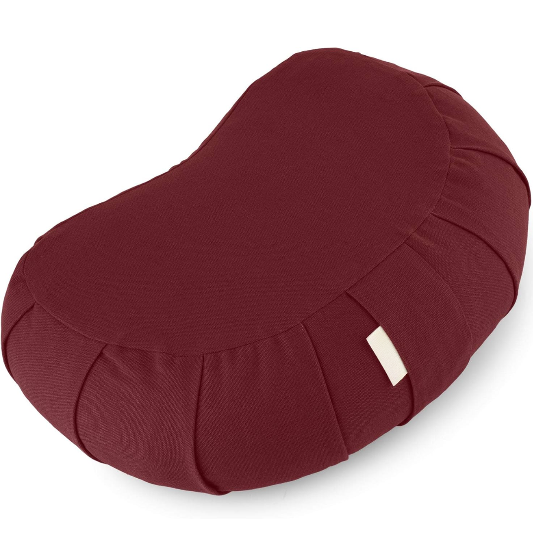 Ergonomic curved meditation cushion, organic cotton, buckwheat fill, supports comfortable long meditation sessions.